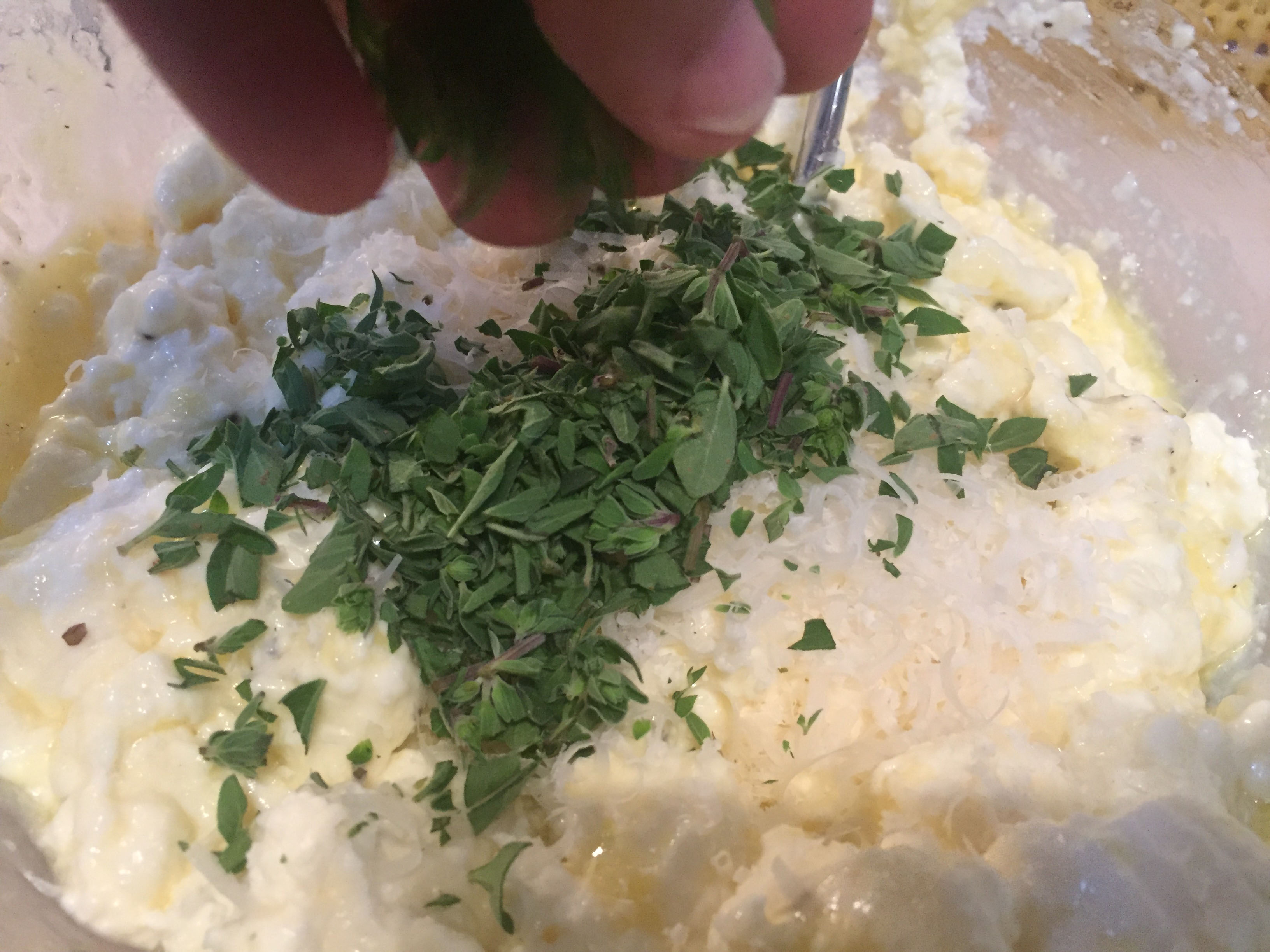 adding herbs to ricotta blend